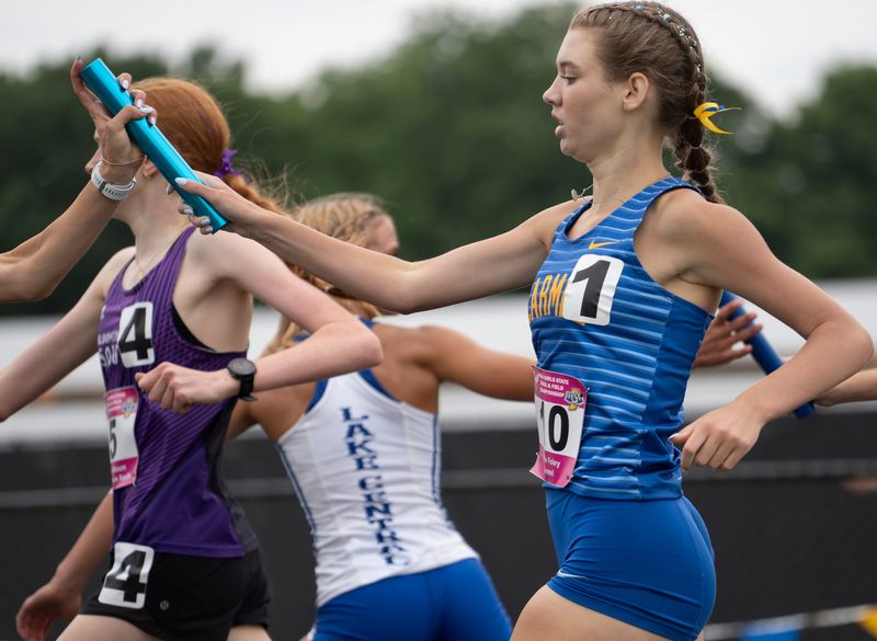 Carmel’s Sadie Foley hands off the baton during the 3200 meter relay Saturday, June 7, 2025, during the IHSAA annual girls state track and field finals in Indianapolis.