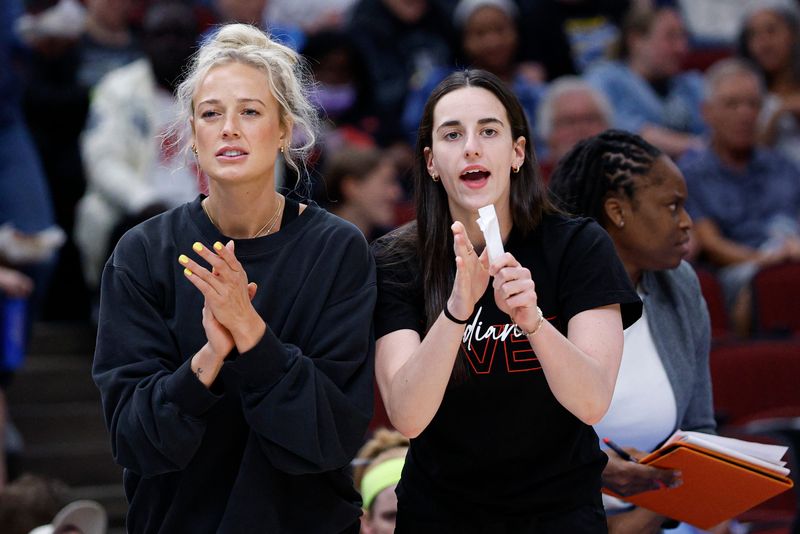 Injured Indiana Fever guard Sophie Cunningham (8) and guard Caitlin Clark (22) react from the bench during the first half of a WNBA game against the Chicago Sky at United Center.