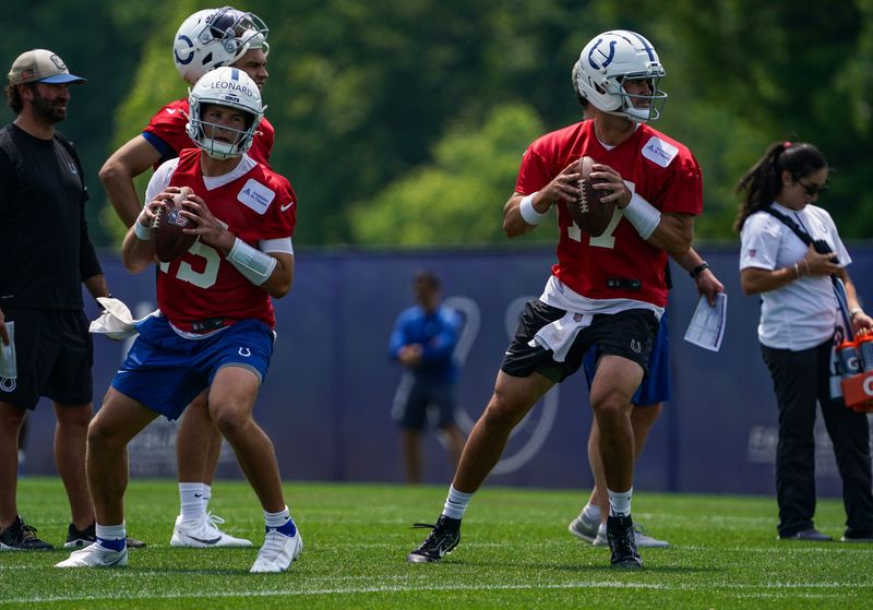 Indianapolis Colts quarterback Daniel Jones (17) searches to pass the ball with Indianapolis Colts quarterback Riley Leonard (15) on Tuesday, June 10, 2025, during NFL Colts mandatory mini camp at the Indiana Farm Bureau Football Center in Indianapolis.