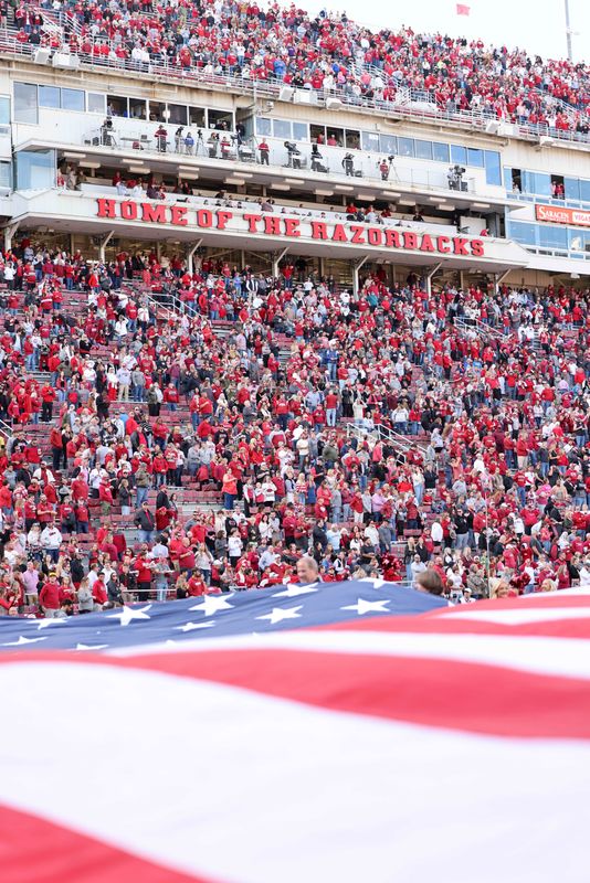 Nov 23, 2024; Fayetteville, Arkansas, USA; A flag is stretched across an end zone during the national anthem prior to a game between the Arkansas Razorbacks and Louisiana Tech Bulldogs at Donald W. Reynolds Razorback Stadium. Mandatory Credit: Nelson Chenault-Imagn Images