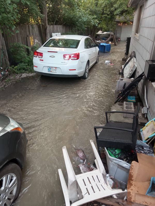 A family's driveway was flooded after a water main broke at the intersection of South Lynhurst Drive and West Morris Street on June 12, 2025 in Indianapolis.