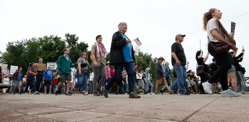 Protesters march across the John T. Myers Pedestrian Bridge Saturday, June 14, 2025, during the “No Kings” protest in Lafayette, Indiana.