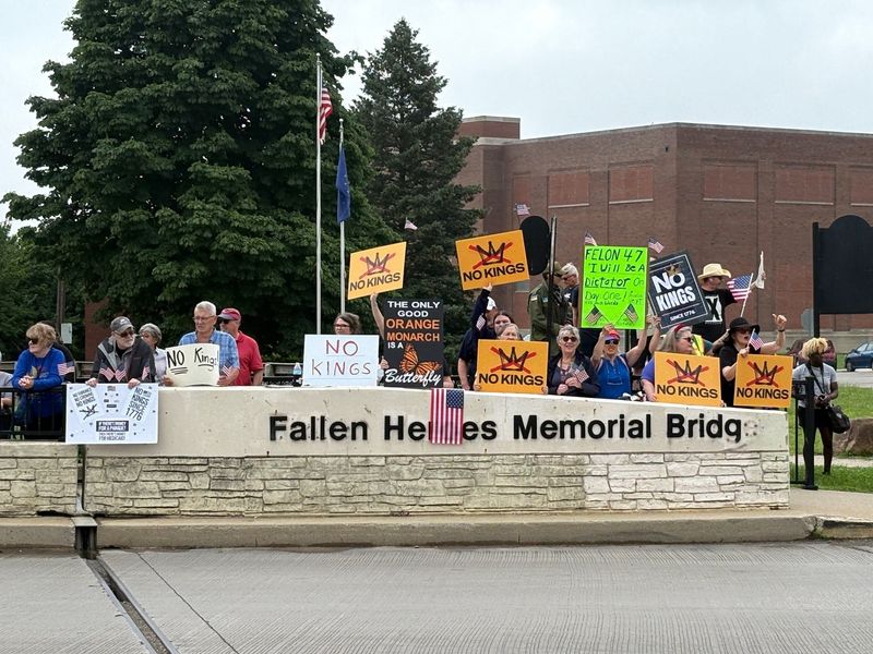 Hundreds of critics of President Donald Trump held a "No Kings" rally on the Fallen Heroes Memorial Bridge, carrying signs along Wheeling Avenue over White River, on Saturday, June 14, 2025.