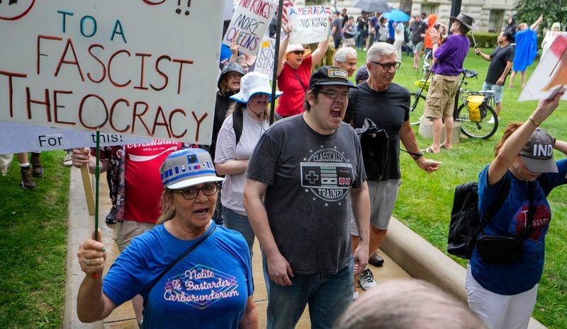Protesters march with signs Saturday, June 14, 2025, during a 'No Kings' protest at the Indiana Statehouse in Indianapolis.