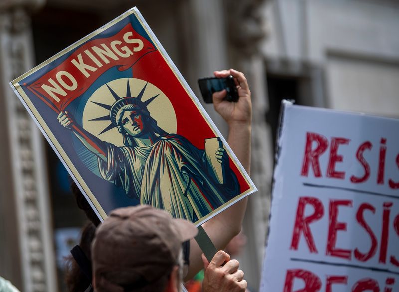 A protester holds a sign as they gather for the "No Kings" protest at the Monroe County Courthouse on Saturday, June 14, 2025.