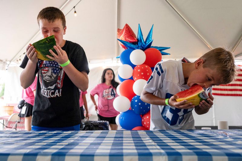 Two young competitors begin the watermelon eating contest on Friday, July 4, 2025, at the Westfield Rocks the 4th event at the Grand Park in Westfield, Ind.