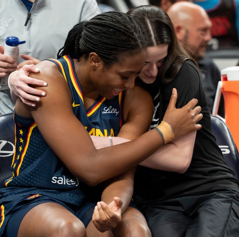 Indiana Fever forward Aliyah Boston (7) and Indiana Fever guard Caitlin Clark (22) embrace on the bench Saturday, July 5, 2025, prior to a game against the Los Angeles Sparks at Gainbridge Fieldhouse in Indianapolis.