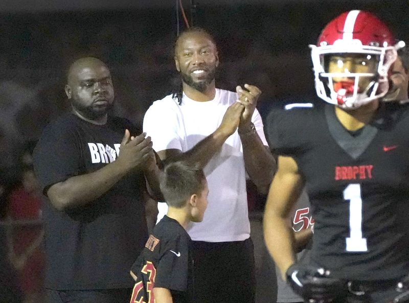 Sep 6, 2024; Phoenix, Ariz., U.S.; Former Arizona Cardinal WR Larry Fitzgerald cheers for his son after Brophy Prep's Devin Fitzgerald (1) scores a touchdown during a game against Regis Jesuit at Central HS football field. Mandatory Credit: Cheryl Evans-Arizona Republic