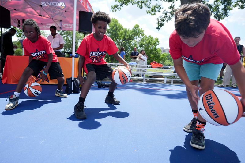Mason Williams, 11, (center) dribbles a basketball during a youth basketball clinic following the unveiling for a new WNBA All-Star Legacy Court on Thursday, July 10, 2025, at Al E. Polin Park in Indianapolis.