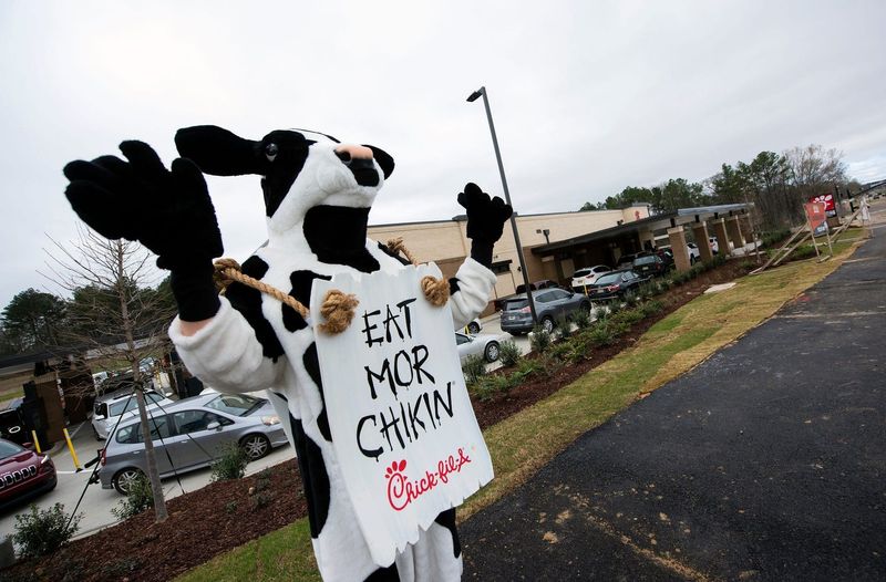 The Chick-fil-A cow waves at passing traffic, welcoming all to the newly-opened restaurant on Highland Colony Parkway near Costco Wholesale in Ridgeland, Miss., Wednesday, March 16, 2022.