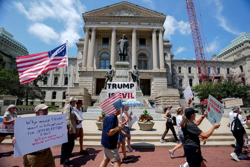 Protesters march with signs Thursday, July 17, 2025, outside of the Indiana Statehouse in Indianapolis.