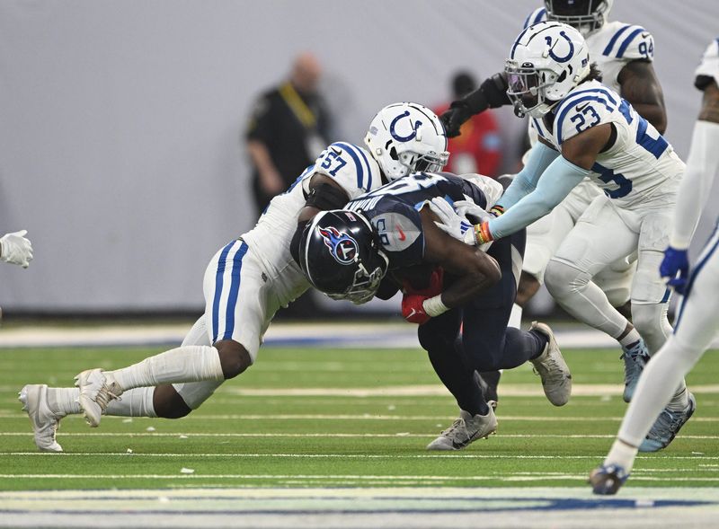 Dec 22, 2024; Indianapolis, Indiana, USA; Tennessee Titans tight end Chig Okonkwo (85) is tackled by Indianapolis Colts linebacker Jaylon Carlies (57) during the second half at Lucas Oil Stadium. Mandatory Credit: Marc Lebryk-Imagn Images