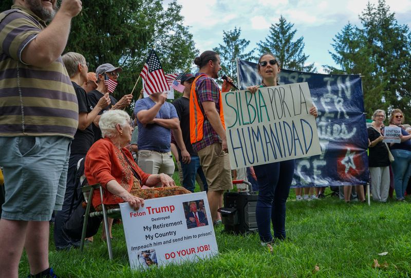 Dozens of demonstrators protest outside of U.S. Sen. Todd Young's office in Carmel, Indiana, as part of one of three protests simultaneously held in Indiana on Sunday, July 20, 2025.