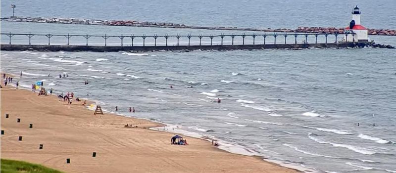This is a frame from the video showing the rescue of two people from a rip current at Michigan City's Washington Park beach on Sunday, July 20, 2025. Notice the rounded area where waves push water the furthest, at far left -- that's where the rip current was.