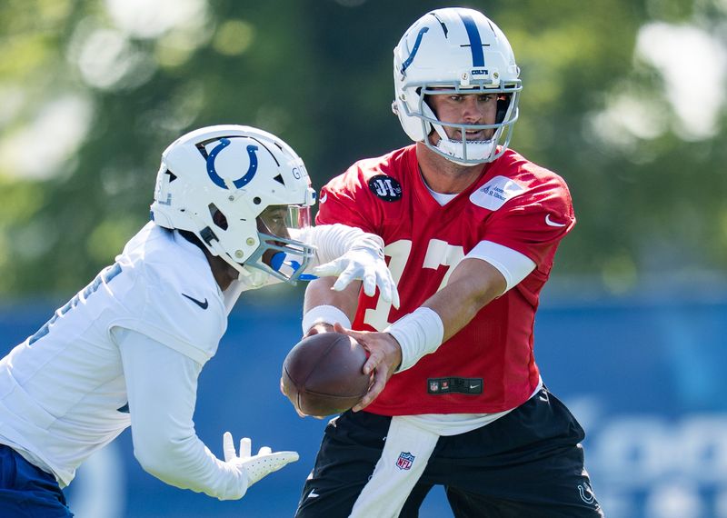 Indianapolis Colts quarterback Daniel Jones (17) hands off to Indianapolis Colts running back DJ Giddens (21) on Wednesday, July 23, 2025, during the first day of training camp held at Grand Park in Westfield.