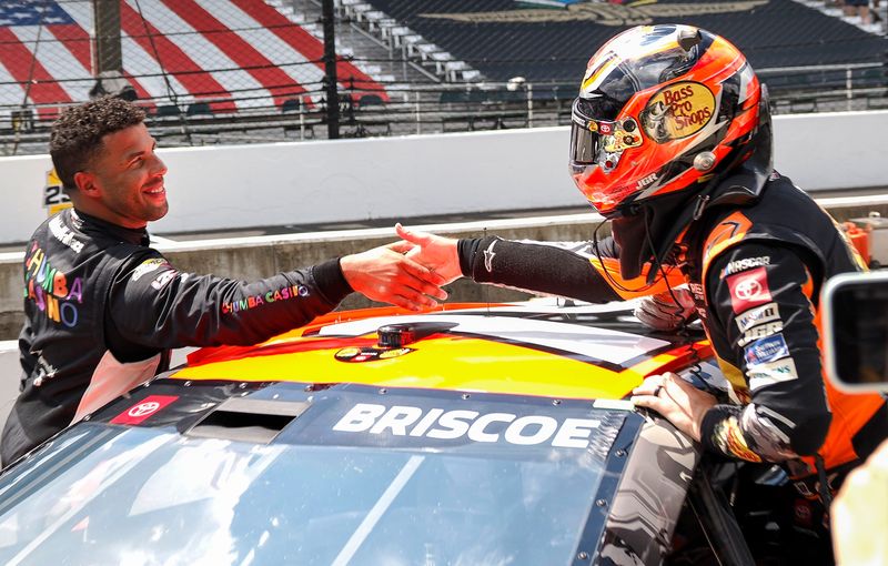 NASCAR Cup Series driver Bubba Wallace (23) shakes hands with NASCAR Cup Series driver Chase Briscoe (19) on Saturday, July 26, 2025, during qualifying for the Brickyard 400 at Indianapolis Motor Speedway.