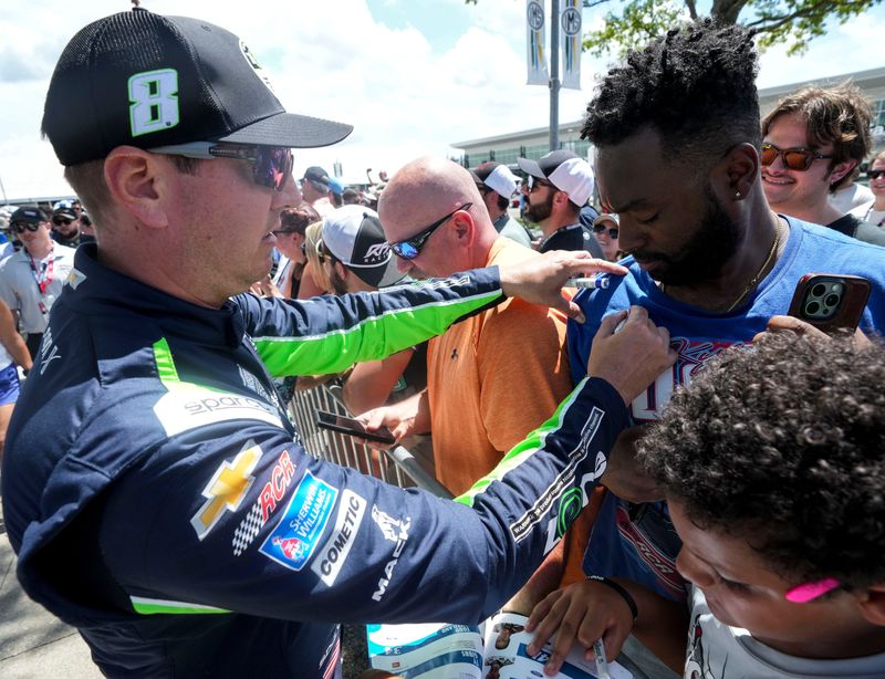 NASCAR Cup Series driver Kyle Busch (8) signs a fan’s shirt Sunday, July 27, 2025, before the Brickyard 400 at Indianapolis Motor Speedway.