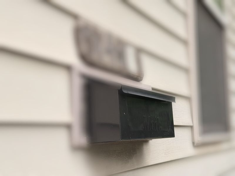 The mailbox that belongs to James Holder's neighbor is nailed to the side of Holder's home in the 100 block of Randolph Street. Shot July 28, 2025.