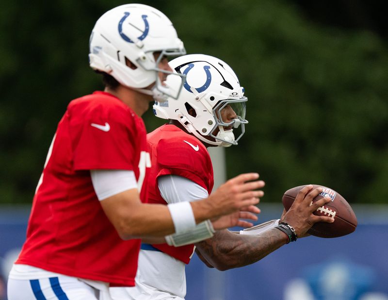 Indianapolis Colts quarterbacks Anthony Richardson Sr. (5) and Daniel Jones (17) drop back to pass Monday, July 28, 2025, during training camp held at Grand Park in Westfield.