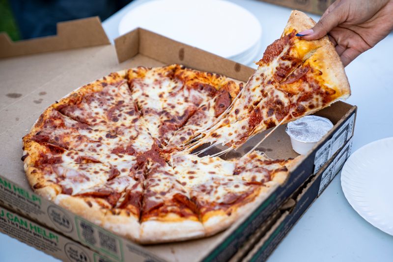 A community member grabs a slice of pizza during National Night Out on Aug. 5, 2025, at Fairmont Park in Des Moines, Iowa.