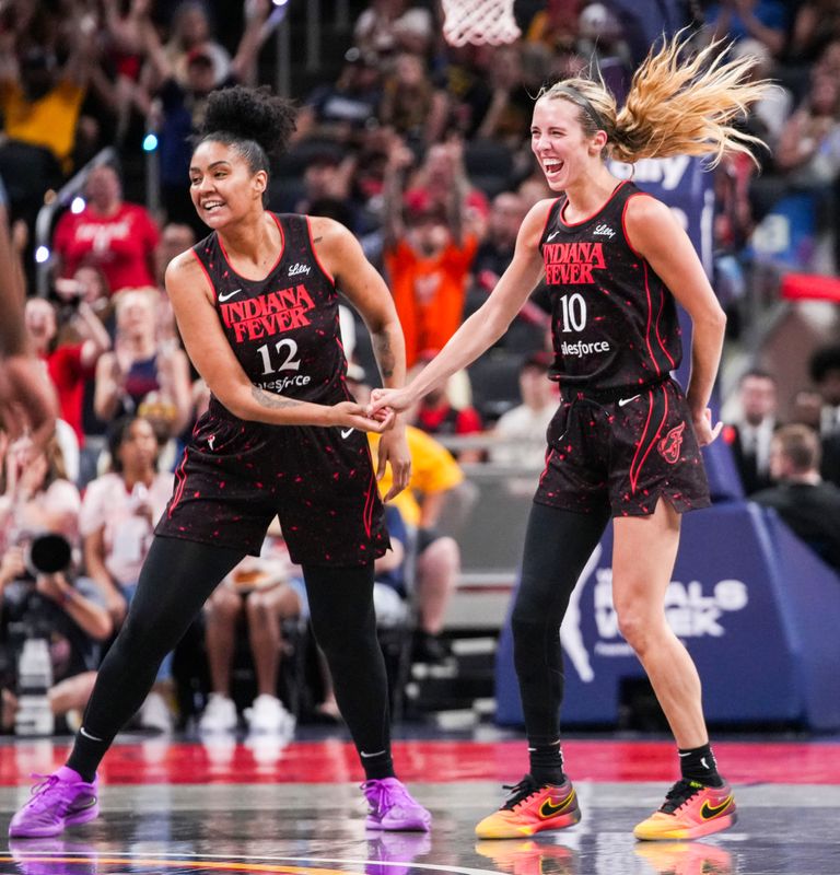 Indiana Fever forward Damiris Dantas (12) and Indiana Fever guard Lexie Hull (10) celebrate a 3-pointer Saturday, Aug. 9, 2025, during a game between the Indiana Fever and the Chicago Sky at Gainbridge Fieldhouse in Indianapolis.