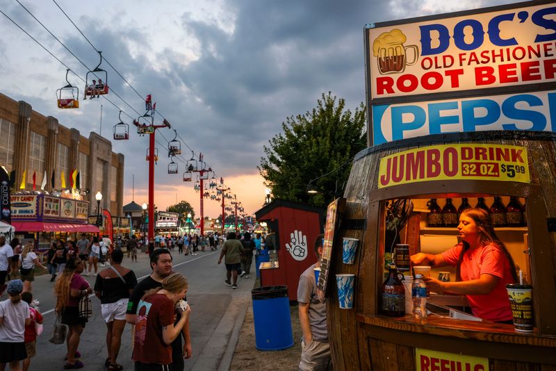 Taylor McNichol, from Georgia, hands out root beer Thursday, Aug. 14, 2025, during the Indiana State Fair at the Indiana State Fairgrounds in Indianapolis