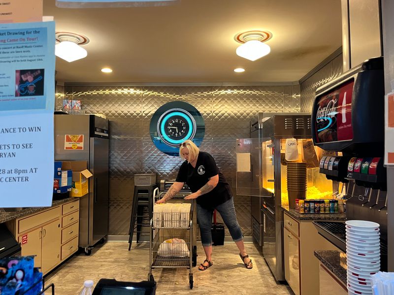 Fowler Theatre Executive Director Jill Byrd bags popcorn as customers trickle into the theater. Byrd has been with the theater 15 years, and has never seen business so slow.