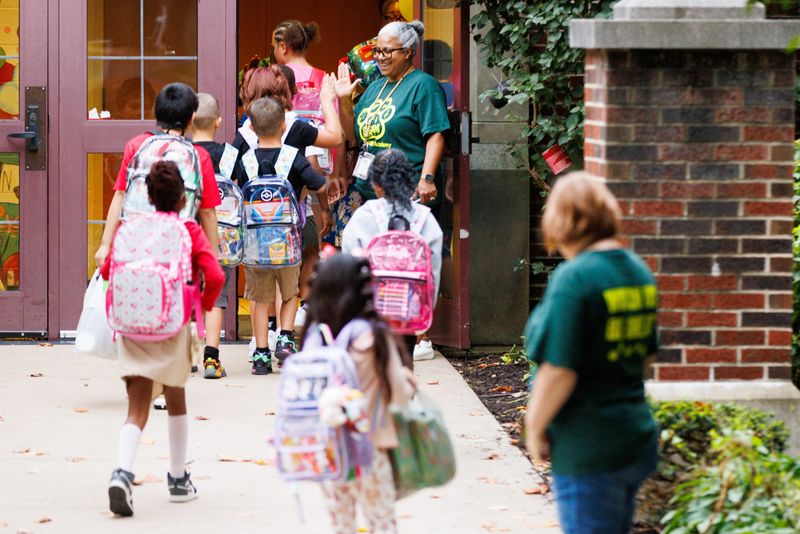 Rolanda Thompson, assistant principal at Madison STEAM Academy, high-fives students as they walk into Madison STEAM Academy for the first day of the 2025-26 school year on Wednesday, Aug. 20, 2025, in South Bend.