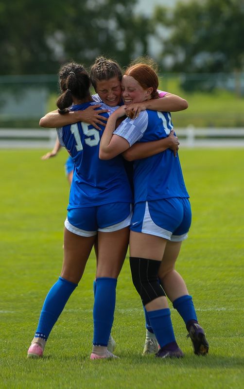Milana Micola (left), Kendall Bradley (middle) and Emma Murphy (right) celebrate a goal against Bellmont in a girls soccer match at Newton Park in Lakeville, August 23, 2025.