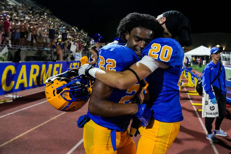 Carmel Greyhounds running back Andrew Pemberton (22) hugs Carmel Greyhounds cornerback Tim McCraw (20) on Friday, Aug. 29, 2025, during a high school football game between the Carmel Greyhounds and the Westfield Shamrocks at Carmel High School. The Carmel Greyhounds defeated the Westfield Shamrocks, 34-10.