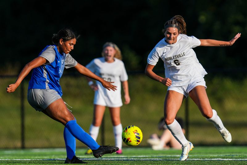 Hamilton Southeastern Royals Sloane May (12) kicks the ball past Noblesville Millers defender Allie Royer (6) on Saturday, Aug. 30, 2025, during a high school soccer game between the Hamilton Southeastern Royals and the Noblesville Millers at Hamilton Southeastern High School in Fishers. The Royals defeated the Millers by mercy rule, 9-0.