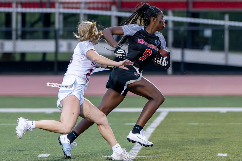 Harrison freshman Ty'Airra Crawford (9) runs past Harrison junior Sydney Neumayr (20) during the IHSAA flag football game between the McCutcheon Mavericks at the Jeff Bronchos Wednesday, Sep. 3, 2025, at Scheumann Stadium in Lafayette, Ind. McCutcheon won 20-16.
