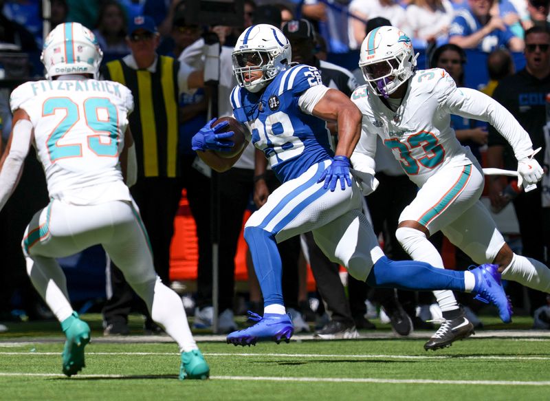 Miami Dolphins safety Minkah Fitzpatrick (29) and cornerback Jason Marshall Jr. (33) attempt to bring down Indianapolis Colts running back Jonathan Taylor (28) during the first half of a game Sunday, Sept. 7, 2025, at Lucas Oil Stadium in Indianapolis. The Colts defeated the Dolphins 33-8.