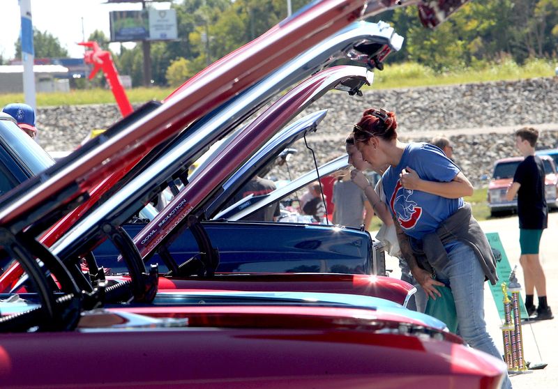 A row of cars with their hoods raised invites inspection by people attending the LCCPS car show in Bedford on Saturday, Sept. 6, 2026. Dozens of entries were there for people to inspect.