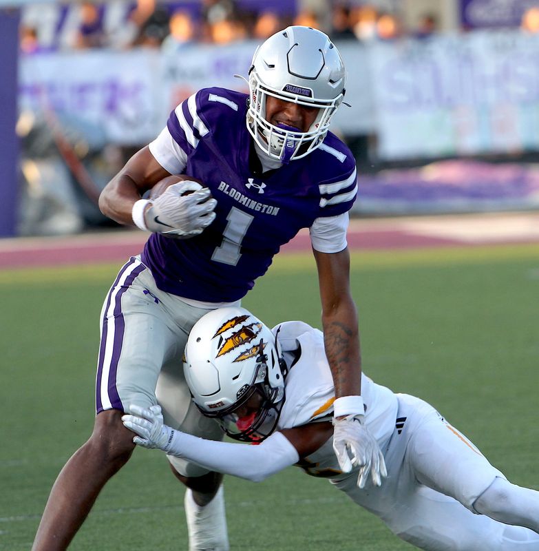 Bloomington South's Jalen Williams (1) slips a tackle by Bloomington North's Nathan Walker (2) during a high school football game Friday, Sept. 12, 2025.