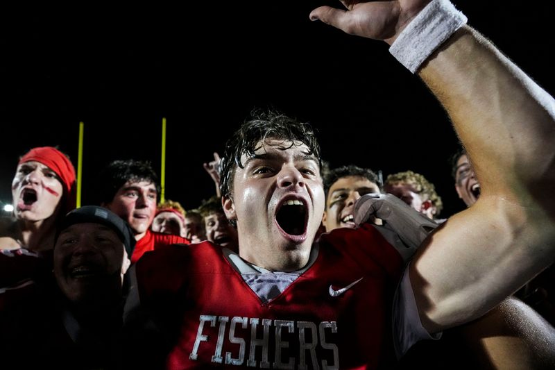 Fishers Tigers quarterback Gage Sturgill (10) yells in excitement Friday, Sept. 12, 2025, after the Mudsock rivalry as Hamilton Southeastern faces Fishers at Fishers High School. The Fishers Tigers defeated the Hamilton Southeastern Royals, 28-16.