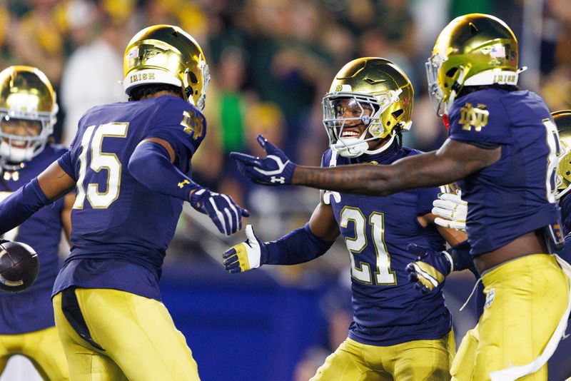Notre Dame cornerback Karson Hobbs (21) and cornerback Leonard Moore (15) celebrate after an interception caught by Moore in the first half of a NCAA football game against Texas A&M at Notre Dame Stadium on Saturday, Sept. 13, 2025, in South Bend.