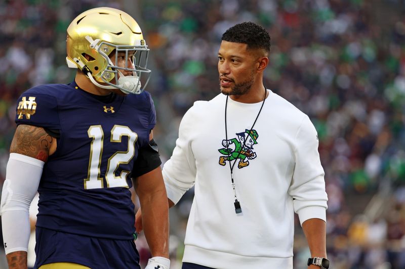 Sep 13, 2025; South Bend, Indiana, USA; Notre Dame head coach Marcus Freeman reacts with Notre Dame Fighting Irish DL Jordan Botelho (12) during the first half against the Texas A&M Aggies at Notre Dame Stadium. Mandatory Credit: Trevor Ruszkowski-Imagn Images