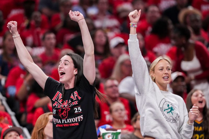 Indiana Fever guard Caitlin Clark (22) and Indiana Fever guard Sophie Cunningham (8) celebrate from the bench Tuesday, Sept. 16, 2025, during Game 2 of a WNBA playoff matchup between the Indiana Fever and the Atlanta Dream at Gainbridge Fieldhouse in Indianapolis.