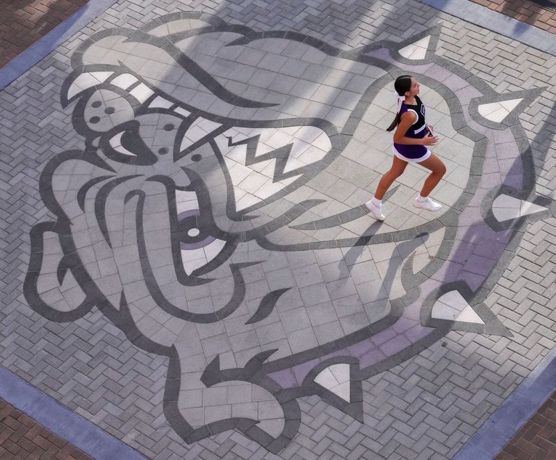 A Brownsburg cheerleader runs across the main entrance pavilion Friday, Sept. 19, 2025, before a game between the Brownsburg Bulldogs and the Fishers Tigers at Brownsburg High School.