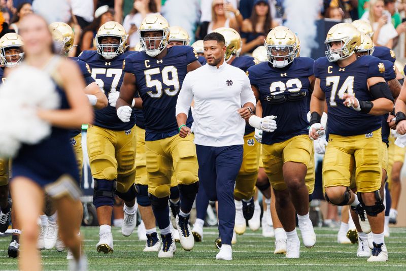 Notre Dame head coach Marcus Freeman, center, takes the field with his team before a NCAA football game against Purdue at Notre Dame Stadium on Saturday, Sept. 20, 2025, in South Bend.