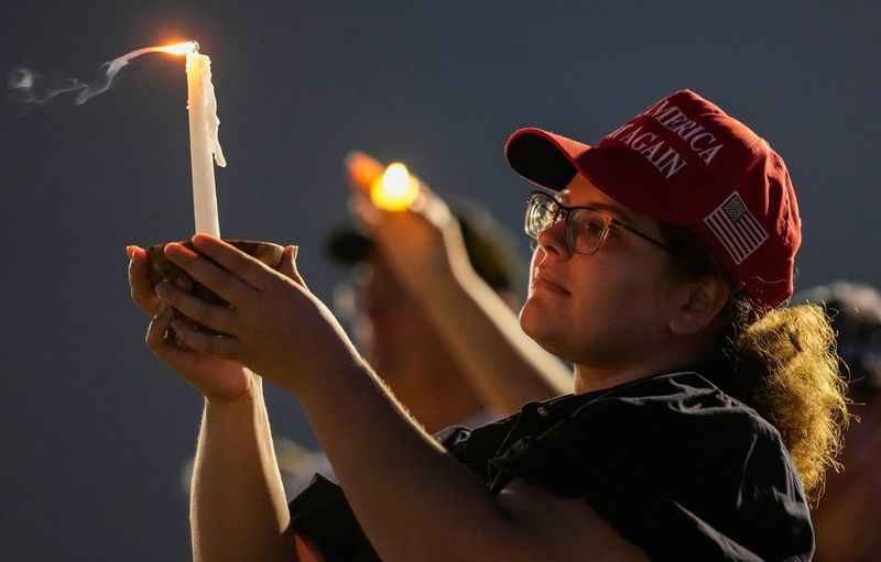 Samantha Sargent from Indianapolis holds a handle Sunday, Sept. 21, 2025, during a vigil for Charlie Kirk at Mulberry Fields in Zionsville.