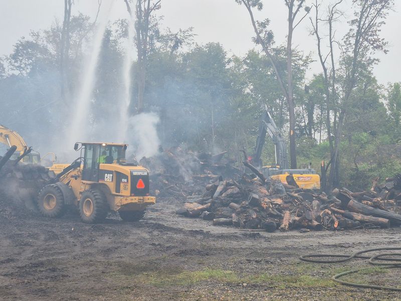 A public composting pile on fire since Sunday in LaPorte continued to burn Wednesday despite the ongoing efforts of firefighters and heavy equipment operators.