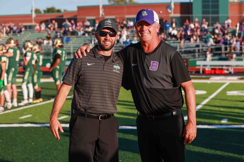 Westfield's Coach Josh Miracle (L) has a friendly pre-game meeting with Brownsburg's Coach John Hart (R) as Brownsburg took on Westfield High School in IHSAA football, Sep 26, 2025; Westfield, IN, United States; at Westfield High School.