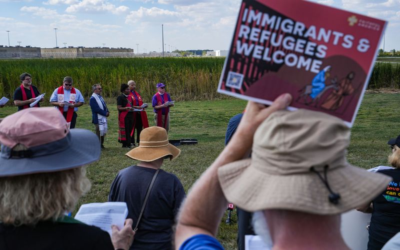 Clergy, church leaders, and people of faith come together with signs and prayer on Monday, Sept. 29, 2025, during a pray vigil outside of the Miami Correctional Facility in Bunker Hill.