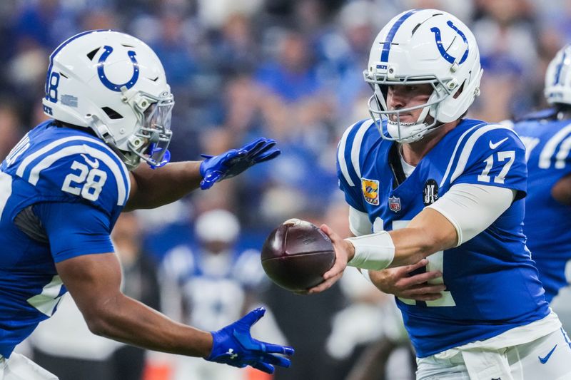 Indianapolis Colts quarterback Daniel Jones (17) hands off the ball to Indianapolis Colts running back Jonathan Taylor (28) on Sunday, Oct. 5, 2025, during a game against the Las Vegas Raiders at Lucas Oil Stadium in Indianapolis.