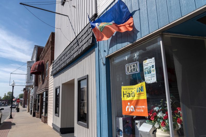 A Haitian flag flows in the wind outside a store on Main Street in Washington, Ind., Wednesday, Oct. 1, 2025. Daviess County has the second highest population of Haitian immigrants in the state. Many members of the community face steep language and cultural barriers that make navigating healthcare, transportation and the job hunt difficult.