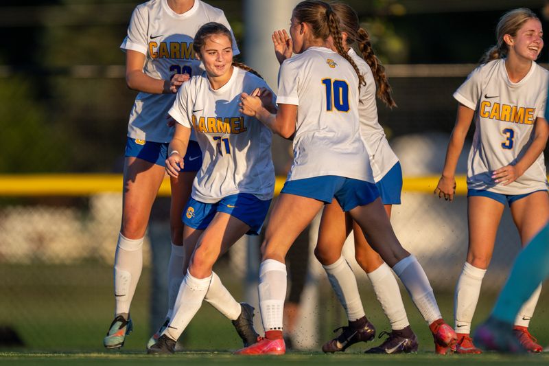 Carmel High School senior Adalyn Cameron (21) celebrates with her teammates after scoring a goal during the second half of a Class 3A girls’ soccer sectional first-round match against Zionsville High School, Wednesday, Oct. 8, 2025, at Zionsville High School in Zionsville, Ind. Carmel won 1-0.