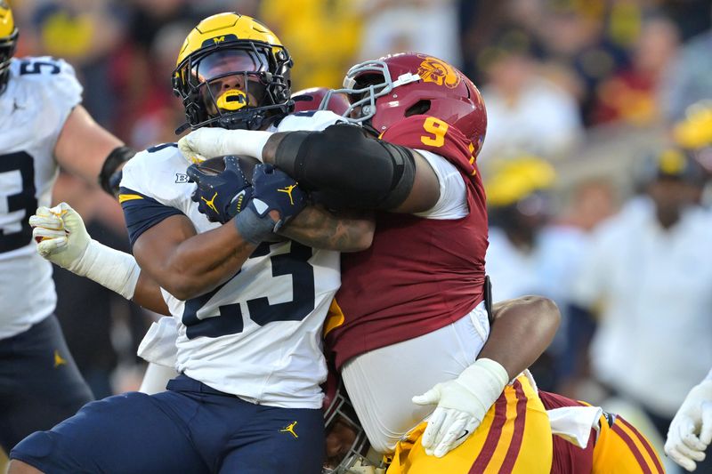 Oct 11, 2025; Los Angeles, California, USA; Michigan Wolverines running back Jordan Marshall (23) is stopped by USC Trojans defensive tackle Keeshawn Silver (9) at the 7-yard line in the first half at United Airlines Field at the Los Angeles Memorial Coliseum. Mandatory Credit: Jayne Kamin-Oncea-Imagn Images