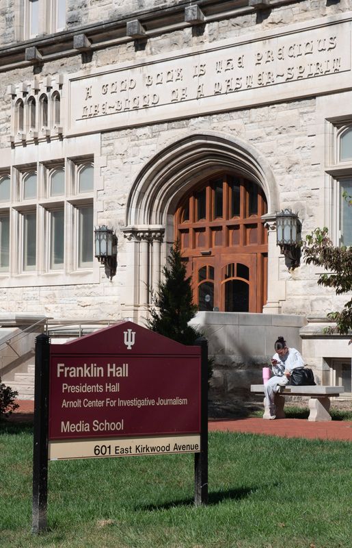 A student checks thier phone outside of Franklin Hall, which is the home of the Arnolt Center for Investigative Journalism and the Indiana Daily Student on Tuesday, Oct. 14, 2025.